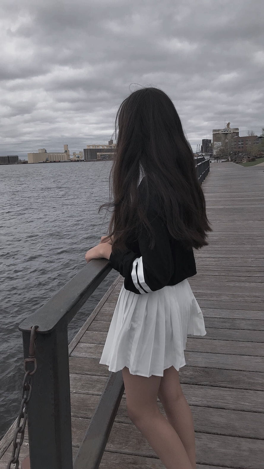 Korean Aesthetic Girl in Black Jacket and White Pleated Skirt on a Lakeside Boardwalk HD phone wallpaper