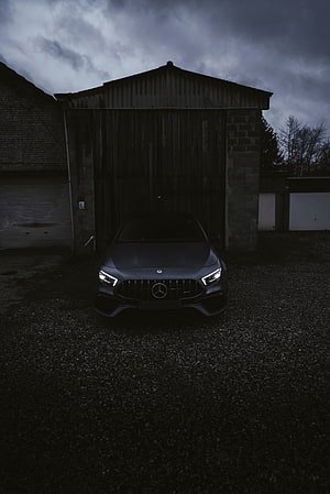 Mercedes-AMG A45 Front View Parked in a Dark Barn Under a Stormy Sky HD phone wallpaper