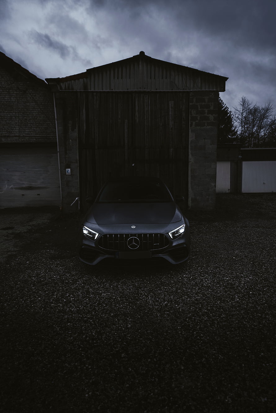 Mercedes-AMG A45 Front View Parked in a Dark Barn Under a Stormy Sky HD phone wallpaper