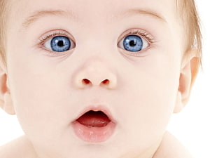 Close-up portrait of a baby with wide blue eyes and an open mouth expression HD wallpaper