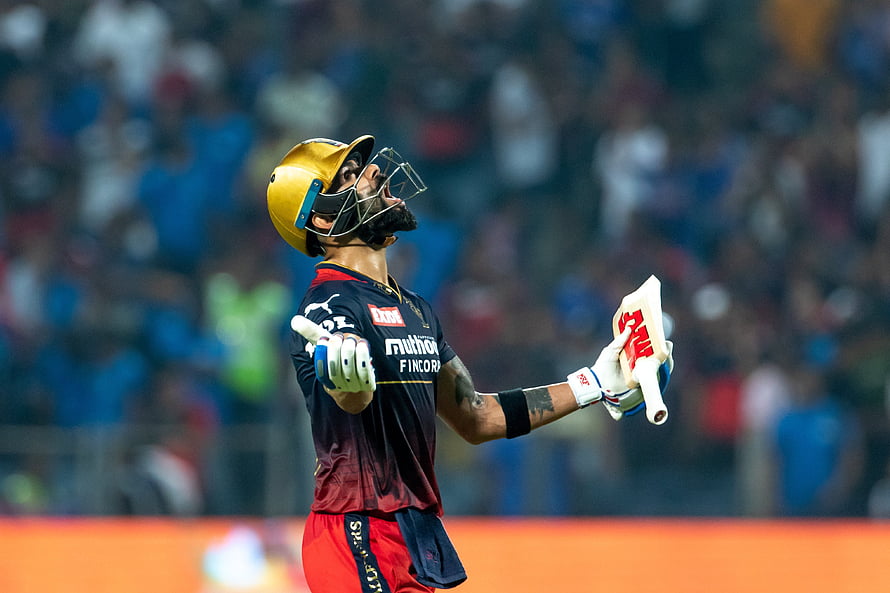 Virat Kohli in Royal Challengers Bengaluru kit holding cricket bat and helmet HD wallpaper
