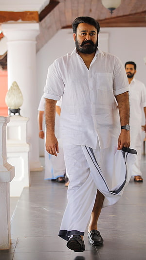 Mohanlal in white traditional attire walking through a corridor in the film Lucifer HD phone wallpaper