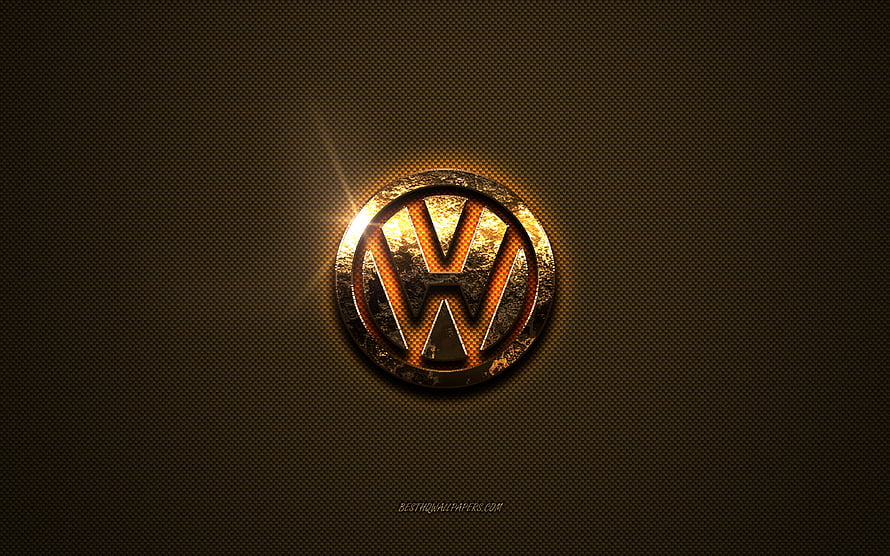 Volkswagen emblem with golden glow on dark textured metal surface HD wallpaper