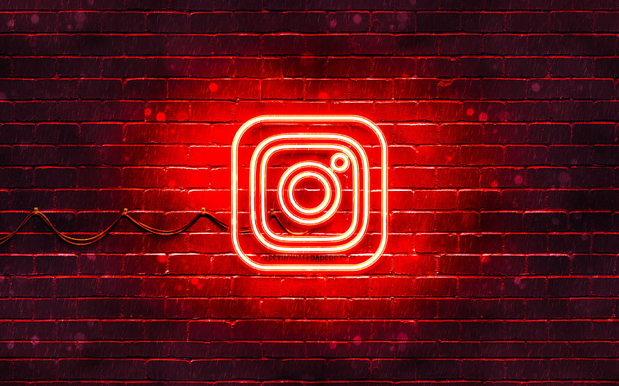 Glowing red Instagram neon sign mounted on a dark brick wall with dramatic lighting HD wallpaper
