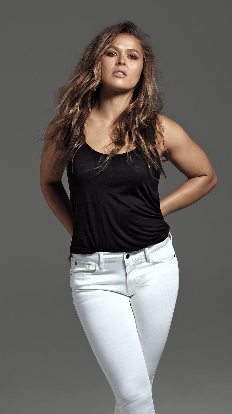 Ronda Rousey Studio Portrait in Black Tank Top and White Jeans HD phone wallpaper
