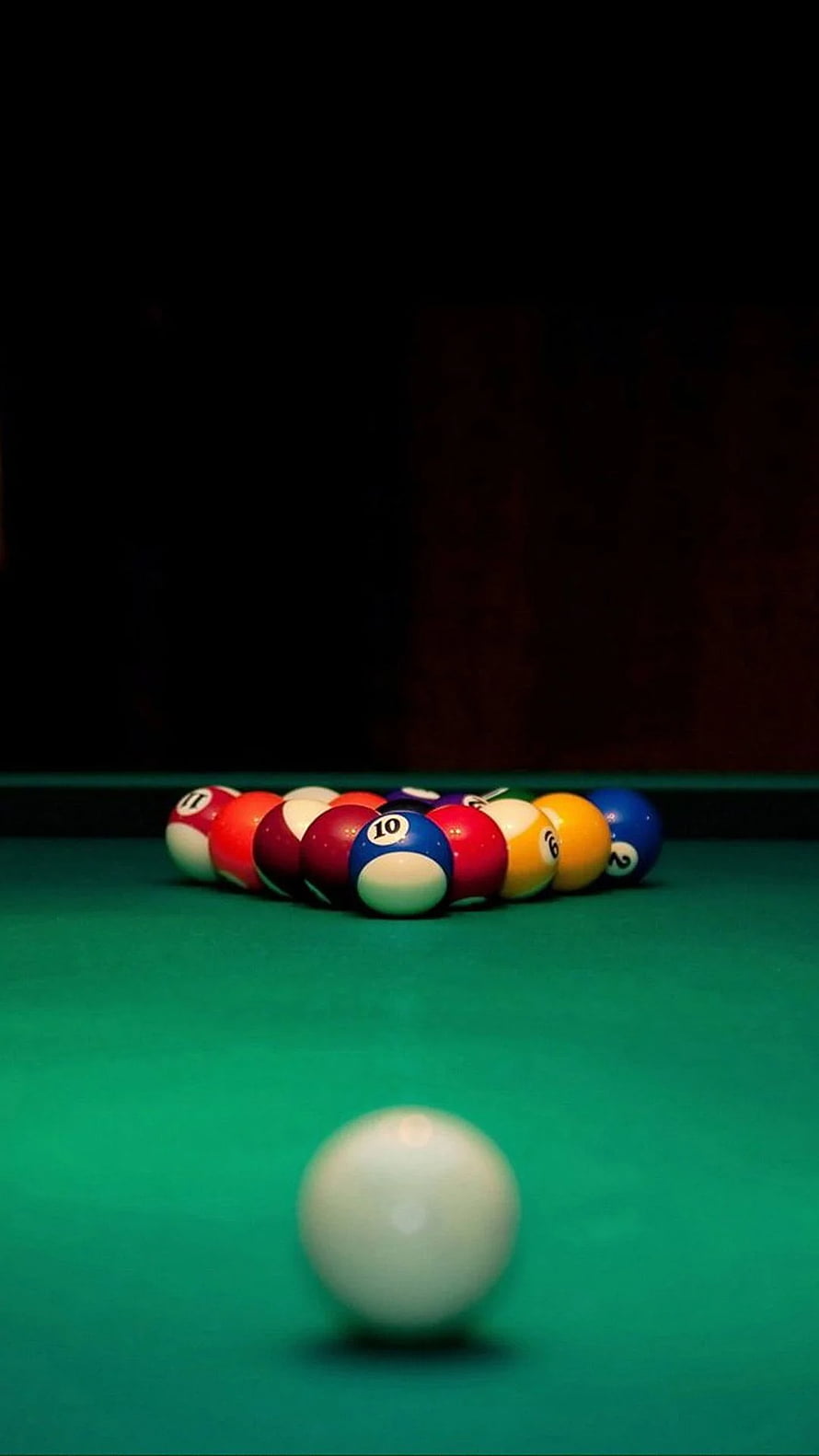 Billiard balls racked on a green felt table with a white cue ball in the foreground HD phone wallpaper