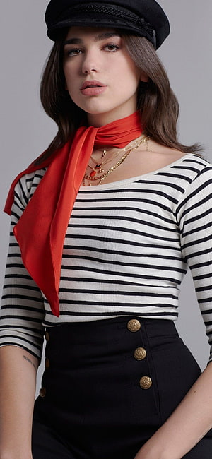 Dua Lipa in a striped top, red scarf, and black beret with layered gold necklaces HD phone wallpaper