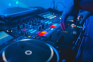 DJ Hands Operating Professional Mixer with Glowing Pads and Turntable in Blue Club Lighting HD wallpaper
