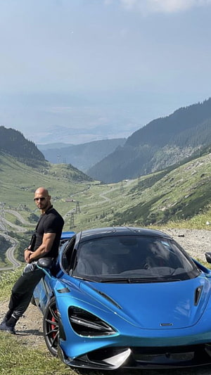 Andrew Tate Leaning Against Blue McLaren 720S on Alpine Mountain Road HD phone wallpaper