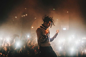 Playboi Carti performing live on stage with dramatic lighting and an energetic crowd HD wallpaper