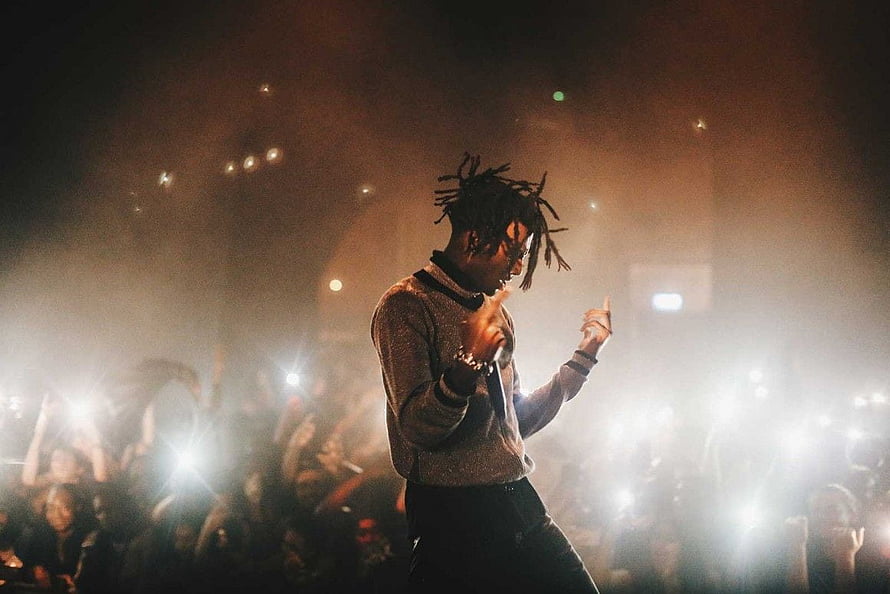 Playboi Carti performing live on stage with dramatic lighting and an energetic crowd HD wallpaper