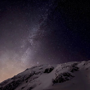 Milky Way Galaxy Arching Over Snow-Capped Mountain Ridge at Night HD phone wallpaper