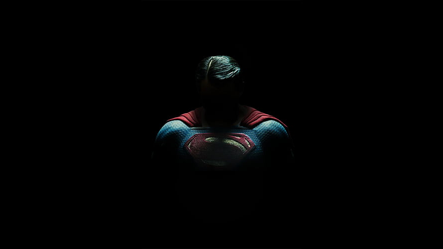 Superman in Dark Suit with Glowing Emblem Against Black Background HD wallpaper