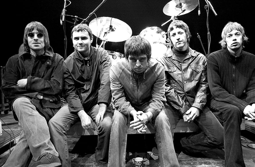 Oasis Band Members Seated on Stage in Black and White Concert Photo HD wallpaper