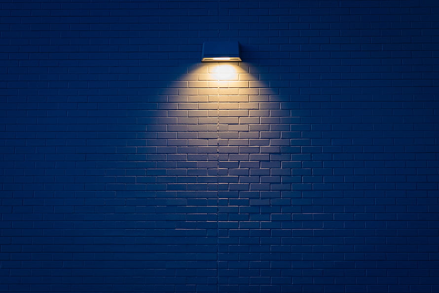 Warm Sconce Light on Dark Blue Brick Wall at Night HD wallpaper