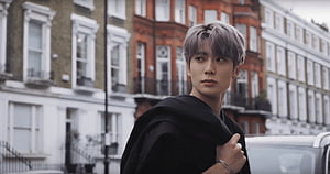 Jaehyun from NCT in a black jacket with silver hair on a London street HD wallpaper