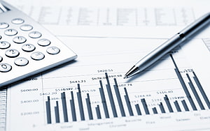 Financial Analysis Workspace with Calculator, Pen, and Bar Chart Report HD wallpaper