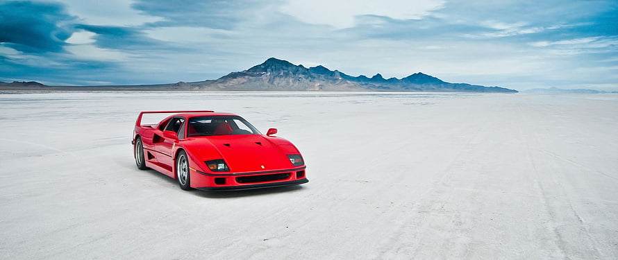 Red Ferrari F40 Super Car on Vast White Salt Flat with Distant Mountain Range HD wallpaper