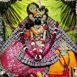 Banke Bihari deity adorned in vibrant floral garlands and ornate temple jewelry HD phone wallpaper