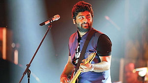 Arijit Singh performing live on stage with electric guitar and microphone HD wallpaper