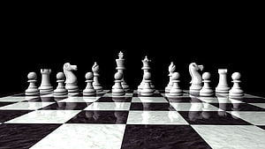 White Chess Pieces Arranged on a Reflective Marble Board Against a Black Background HD wallpaper