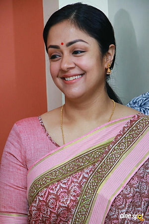 Jyothika smiling in a pink and maroon patterned sari with gold jewelry HD phone wallpaper