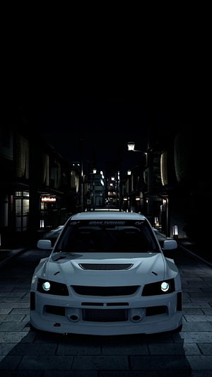 White Mitsubishi Lancer Evolution V parked on a dark Japanese street at night with headlights on HD phone wallpaper