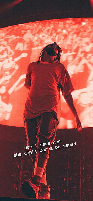 J. Cole performing on stage with red lighting and a large crowd in the background HD phone wallpaper
