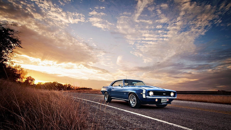 Blue Classic Muscle Car Driving on a Country Road at Sunset HD wallpaper