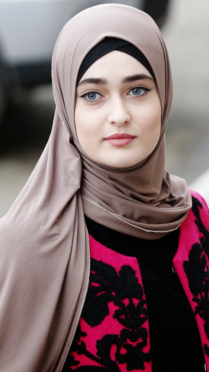 Portrait of a young woman wearing a beige hijab and a pink and black patterned cardigan HD phone wallpaper