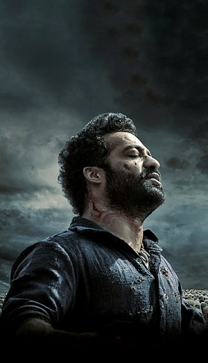 RRR Movie Poster Featuring NTR in Dramatic Stormy Sky Portrait HD phone wallpaper
