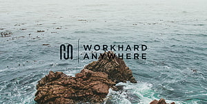 Work Hard Anywhere Logo Over Dramatic Ocean Rocks and Waves HD wallpaper