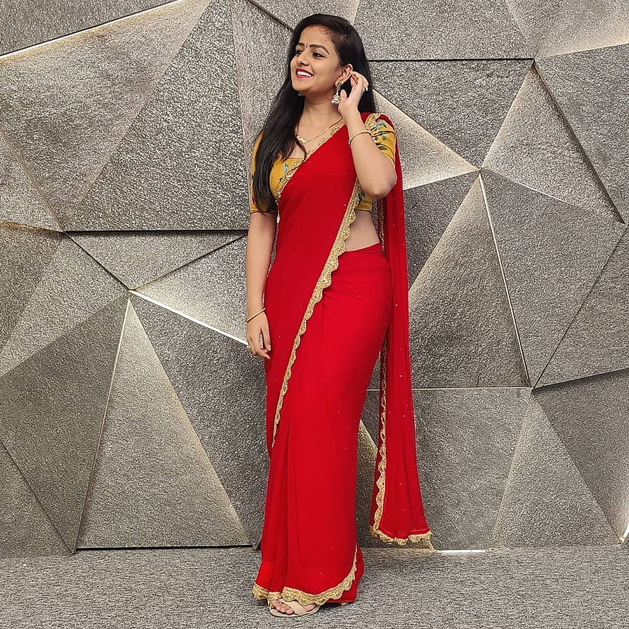 Vaishnavi Chaitanya in a red and gold saree against a geometric stone wall HD phone wallpaper