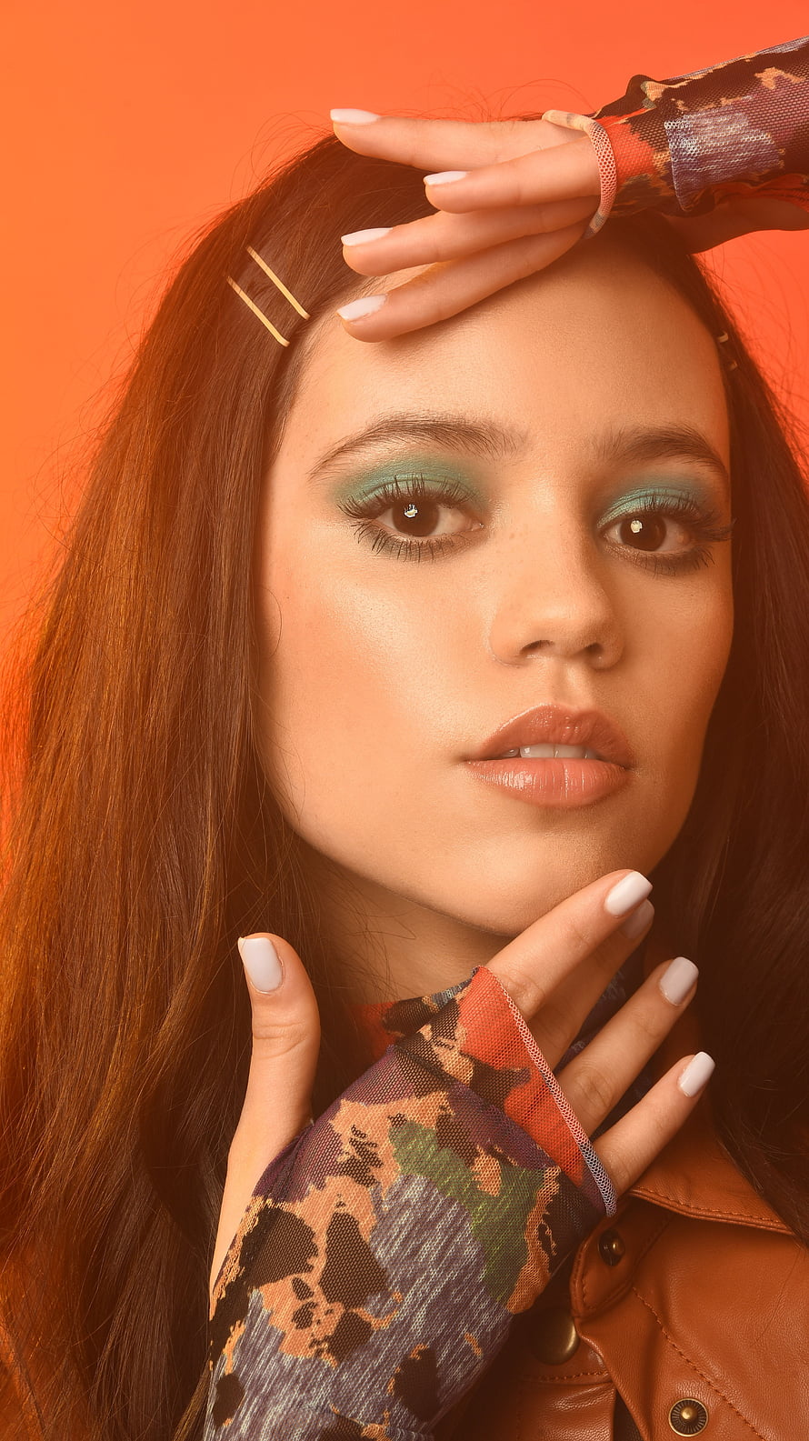 Jenna Ortega Portrait with Teal Eyeshadow and Camouflage Sleeves on Orange Background HD phone wallpaper