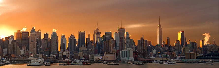 New York City Skyline at Golden Hour with Dramatic Sunset and Waterfront View HD wallpaper