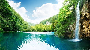 Serene Waterfall Cascading Into Turquoise Lake Surrounded By Lush Green Forest HD wallpaper