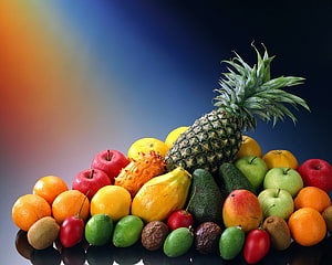 Vibrant tropical fruit arrangement with pineapple, mango, avocado, and citrus on a dark background HD wallpaper