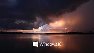 Windows 10 Default Wallpaper Featuring Dramatic Storm Clouds Over a Calm Lake at Sunset HD wallpaper