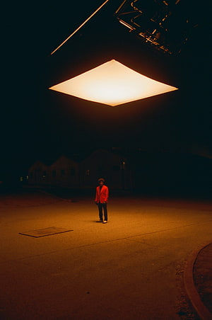 The Weeknd in red jacket under warm spotlight in After Hours album artwork HD phone wallpaper