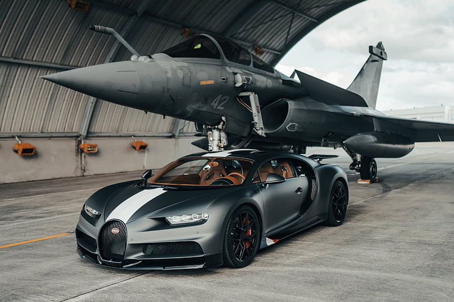 Matte Black Bugatti Chiron Parked in Front of a Military Fighter Jet in Hangar HD wallpaper