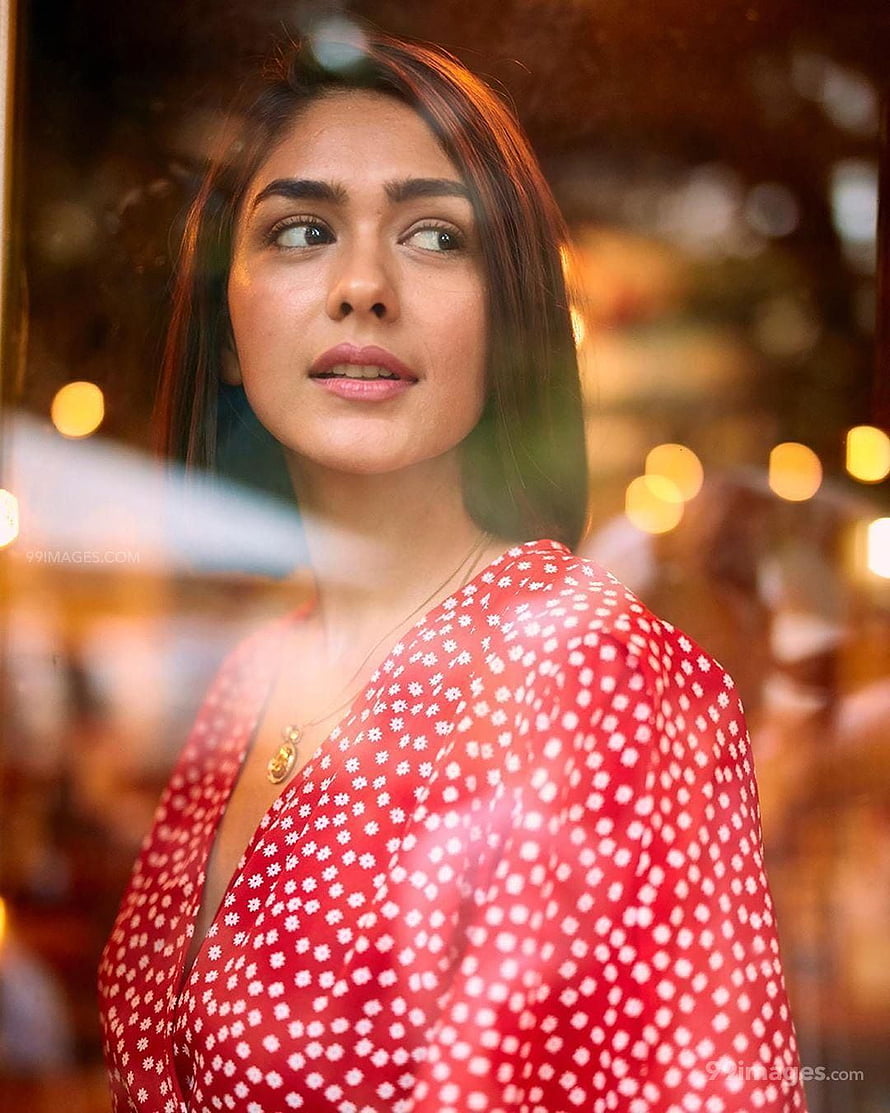 Mrunal Thakur in a red floral dress gazing through a window with warm bokeh lights HD phone wallpaper