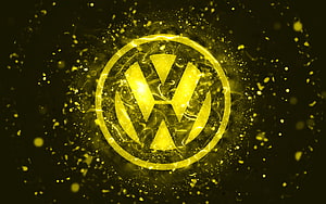 Volkswagen emblem glowing in golden neon light with abstract particle effects on a dark background HD wallpaper
