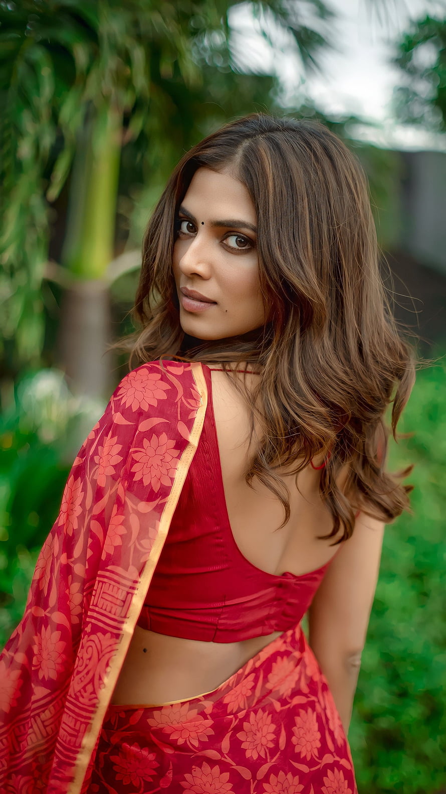 Malavika Mohanan in a Red Floral Saree with Gold Border in a Lush Garden HD phone wallpaper