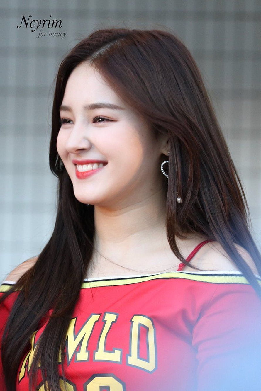 Nancy from MOMOLAND smiling in a red off-shoulder jersey with long dark hair and heart earrings HD phone wallpaper