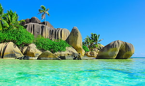 Tropical Island Beach With Granite Boulders, Palm Trees, And Turquoise Water HD wallpaper
