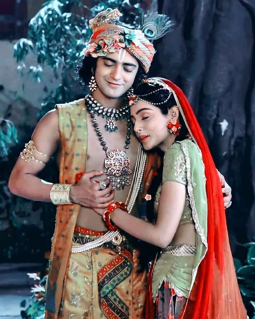 Radha Krishna in Traditional Indian Attire Embracing in a Lush Garden Setting HD phone wallpaper