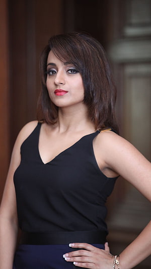 Trisha Krishnan in a black sleeveless top with red lipstick and a confident pose HD phone wallpaper