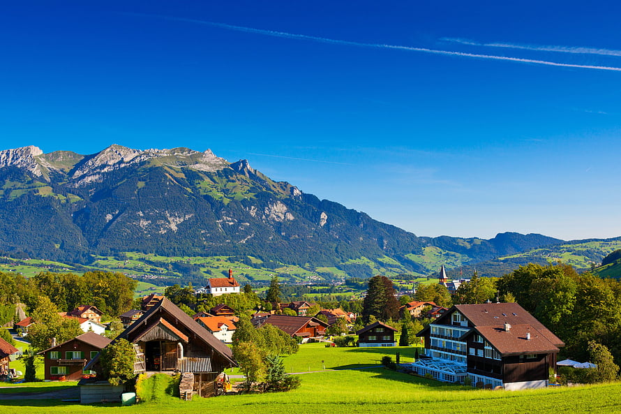 Swiss Alpine Village with Traditional Chalets and Mountain Backdrop HD wallpaper