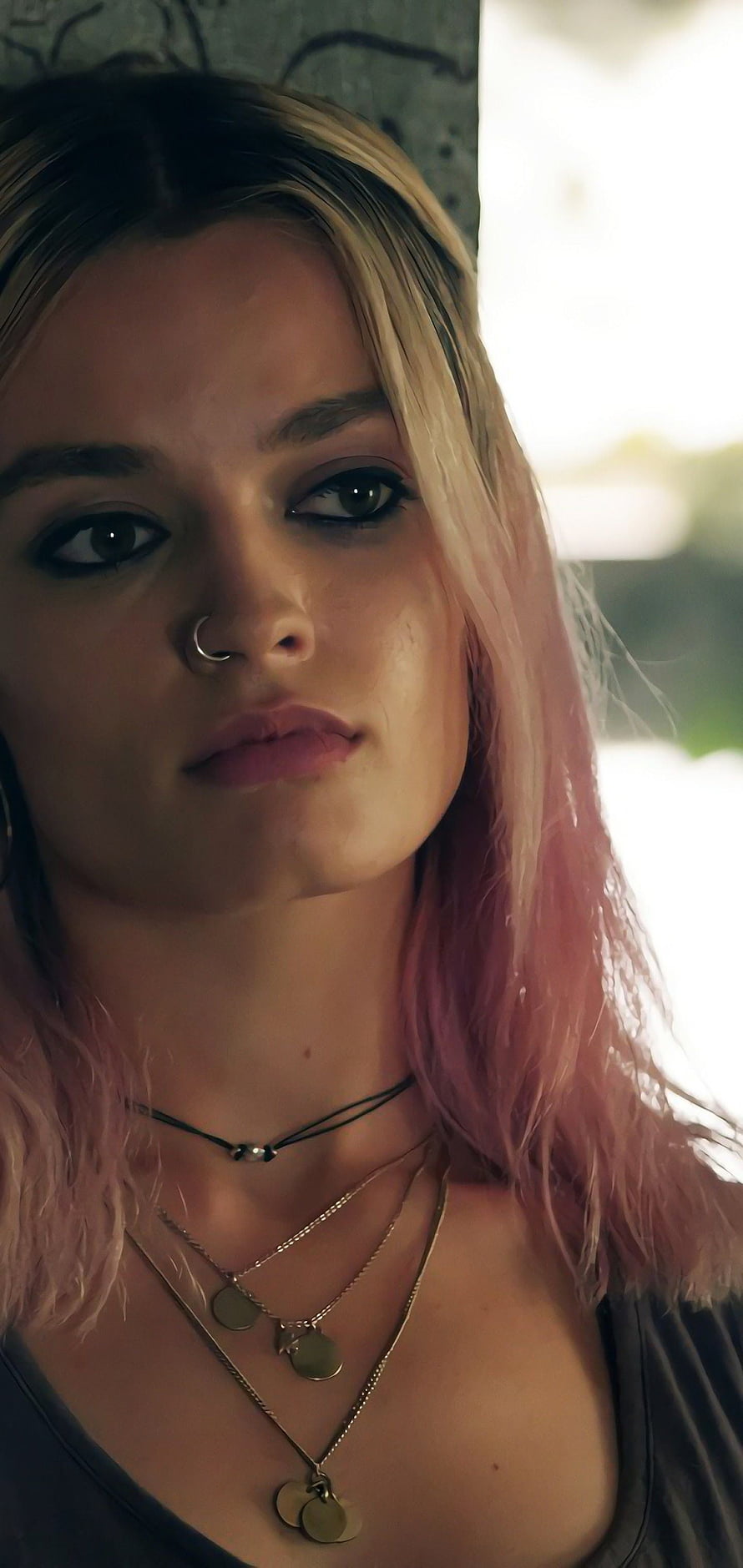 Maeve from Sex Education with pink hair and layered necklaces in a moody close-up portrait HD phone wallpaper