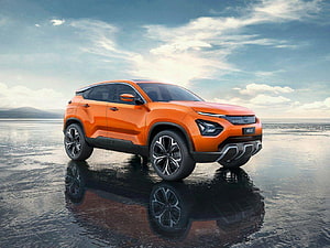 Orange Tata Nexon SUV Concept on Wet Reflective Surface Under Cloudy Sky HD wallpaper